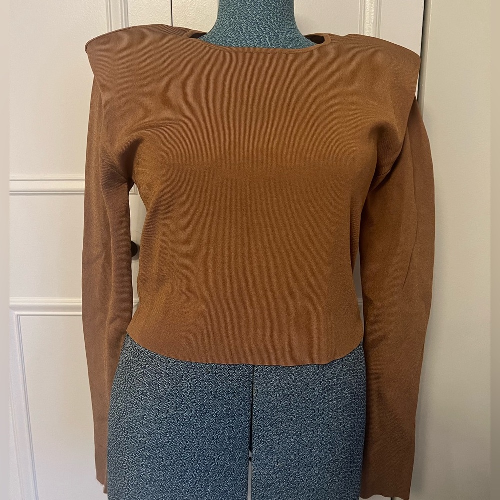 Express long sleeve fitted top with shoulder pads and open back.